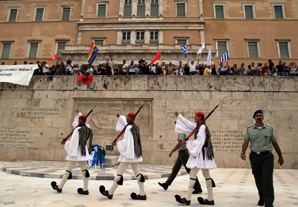 epa04813209 Protesters watch the change of guards process, as they rally against austerity and in support to the government in the negotiations with Greece&#039;s international creditors, in Syntagma  ...