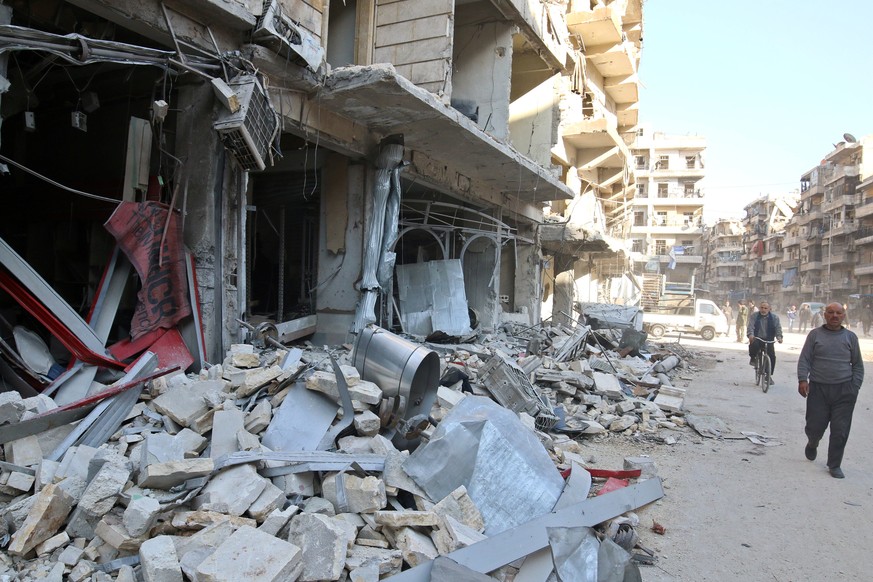 Men walk past damaged shops at a site hit yesterday by airstrikes in the rebel held al-Shaar neighbourhood of Aleppo, Syria November 17, 2016. REUTERS/Abdalrhman Ismail