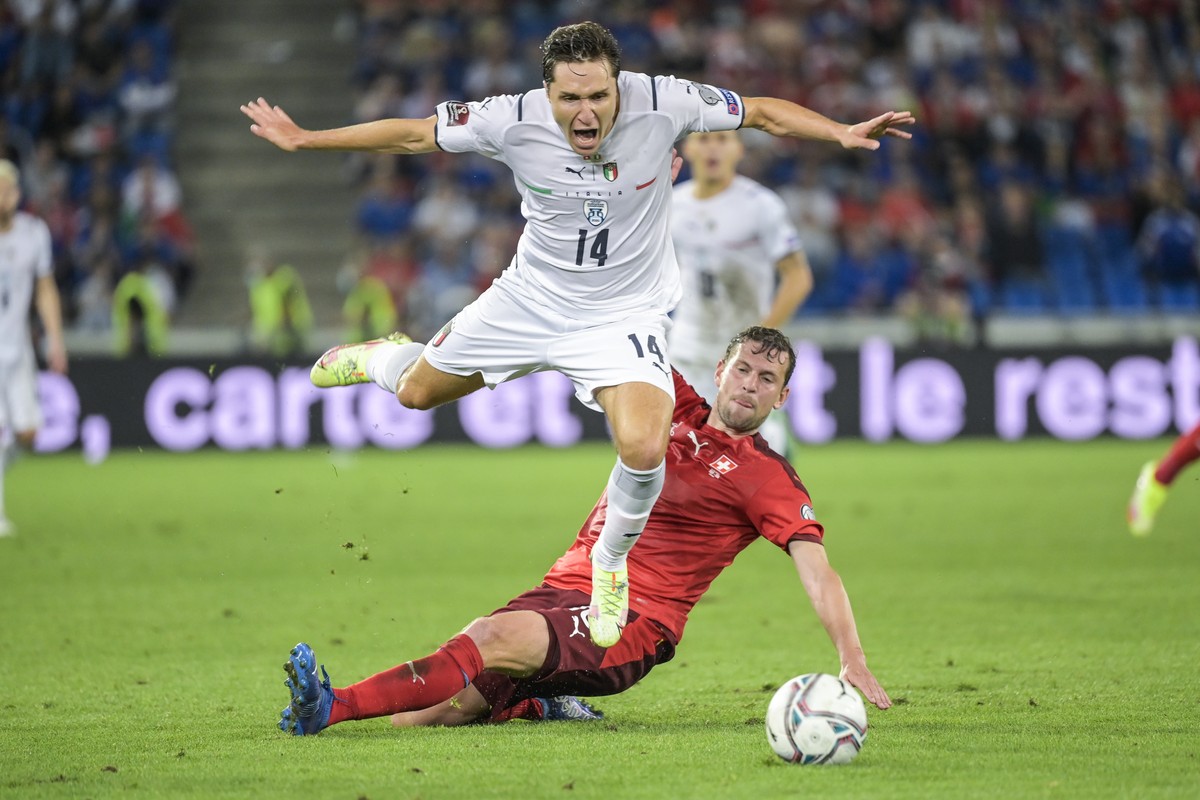 Italy's Federico Chiesa, left, fights for the ball against Switzerland's Fabian Frei, during the 2022 FIFA World Cup European Qualifying Group C soccer match between Switzerland and Italy at ...