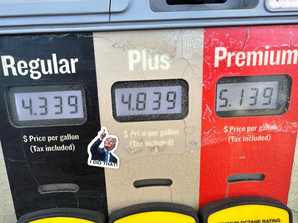 A sticker with the image of President Donald J. Trump points to the electronically-displayed per-gallon prices for the various grades of gasoline available from a pump at a Conoco station Saturday, Ma ...