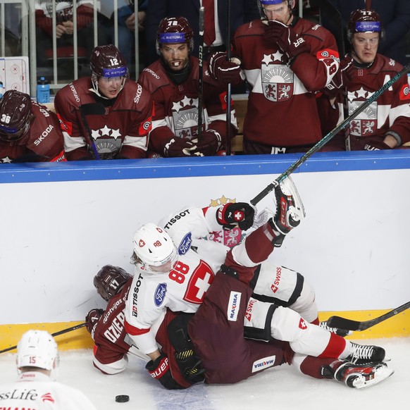 epa12052159 Latvia&#039;s Martins Dzierkals and Markuss Komuls (R) in action against Switzerland&#039;s Gregory Hofmann (L) and Christoph Bertschy during the friendly international ice hockey match be ...