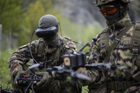 Soldaten posieren mit einer First Person View (FPV) Angriffsdrohne an einem Medienanlass der Schweizer Armee zur Einbindung von Drohnen in Kampfverbaende, am Montag, 18. Mai 2026, auf dem Schiessplatz ...