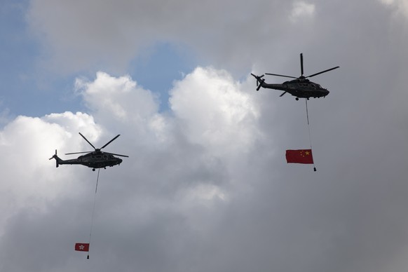 epa09314687 Helicopters carrying the Chinese and the Hong Kong flags do a fly by during a flag-raising ceremony marking the 24th anniversary of the establishment of the Hong Kong Special Administrativ ...
