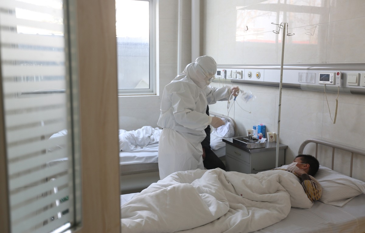 epa08212643 A doctor takes care of a fever patient in an isolation ward in a hospital in Yinan County, in east China's Shandong province, 12 February 2020. The disease caused by the new coronavir ...
