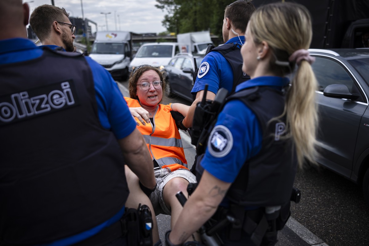 epa10699523 An environmental activist of 'Renovate Switzerland' civil resistance campaign reacts as she is detained by the police after sitting down on the road during a roadblock action on  ...
