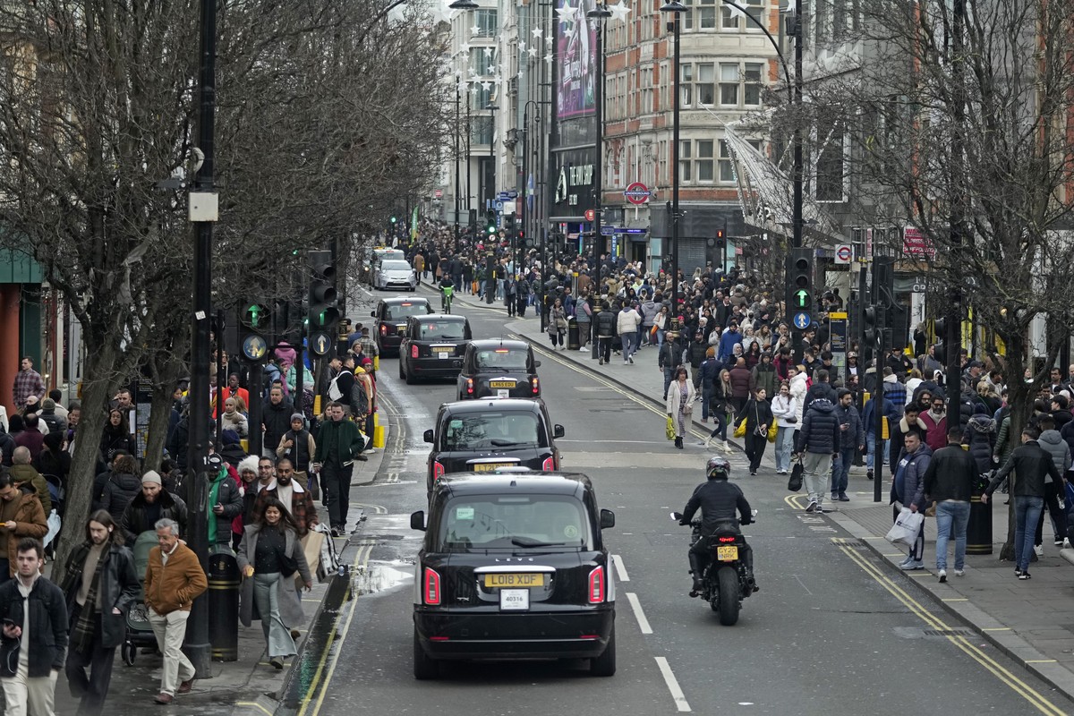 Shoppers walk along Oxford Street during the Boxing Day sales in London, Tuesday, Dec. 26, 2023. (AP Photo/Kin Cheung)