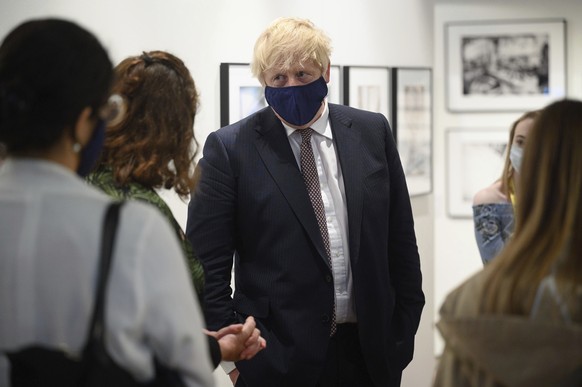 Britain&#039;s Prime Minister Boris Johnson discusses the foreign aid cap with a member of an engagement group during a visit to Falmouth&#039;s Maritime Museum to meet volunteers and to thank them fo ...