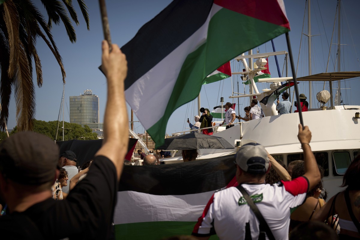 Demonstrators shout slogans on a boat ahead of the launch of a civilian flotilla bound for Gaza, aiming to break the Israeli blockade and deliver humanitarian aid in Barcelona, Spain, Sunday, Aug. 31, ...