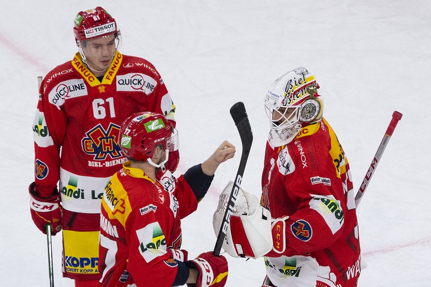 Biels Michael Huegli, Robin Grossmann und Torhueter Joren Van Pottelberghe, von links, feiern ihren Sieg im Eishockey Meisterschaftsspiel der National League zwischen dem EHC Biel und dem EV Zug, am S ...