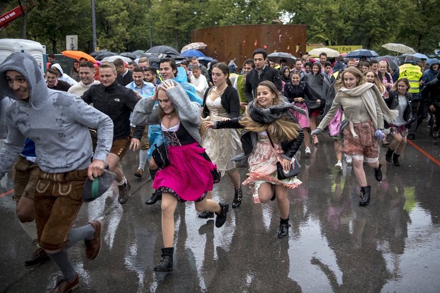 epa06207837 Visitors run during the opening of the 184rd edition of the traditional Oktoberfest beer and amusement festival in the German Bavaria state&#039;s capital Munich, Germany, 17 September 201 ...