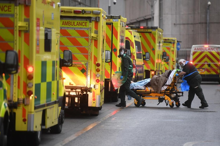epa08920554 Medical professionals transfer a patient from ambulance to the Royal London Hospital in London, Britain 05 January 2021. Britain&#039;s Prime Minister Boris Johnson announced a new nationa ...