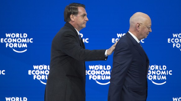 Brazil&#039;s President Jair Bolsonaro, left, leves the stage next to German Klaus Schwab, right, Founder and Executive Chairman of the World Economic Forum, WEF, after a plenary session in the Congre ...
