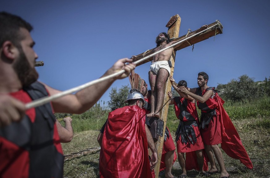 epa04691078 Local men reenact the crucification of Jesus Christ on Good Friday in Qraiyeh, southern Lebanon, 03 April 2015. EPA/OLIVER WEIKEN