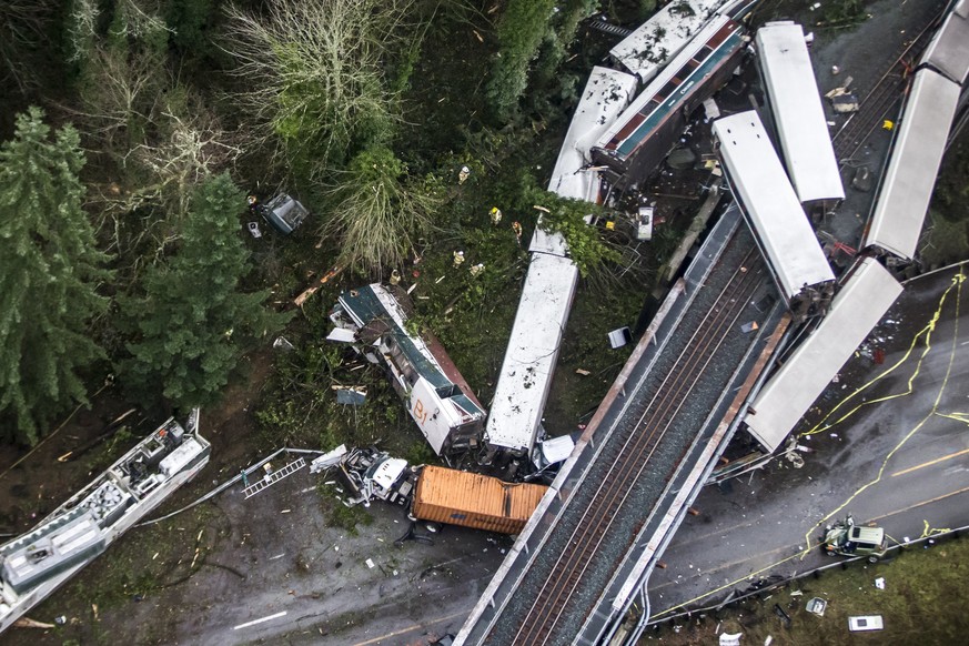 Cars from an Amtrak train that derailed above lie spilled onto Interstate 5, Monday, Dec. 18, 2017, in DuPont, Wash. The Amtrak train making the first-ever run along a faster new route hurtled off the ...