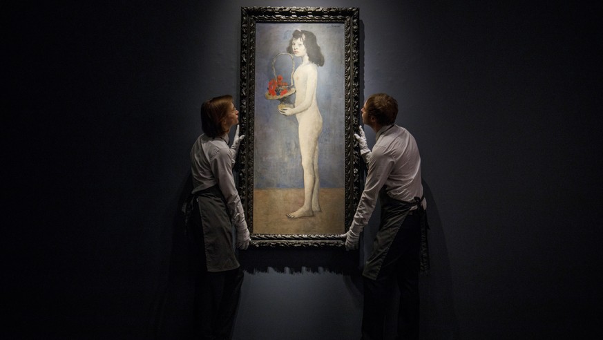 epa06719524 (FILE) - Gallery assistants pose with the painting &#039;Fillette a la corbeille fleurie&#039; (Girl with flower basket) by Spanish artist Pablo Picasso during a photocall at Christie&#039 ...