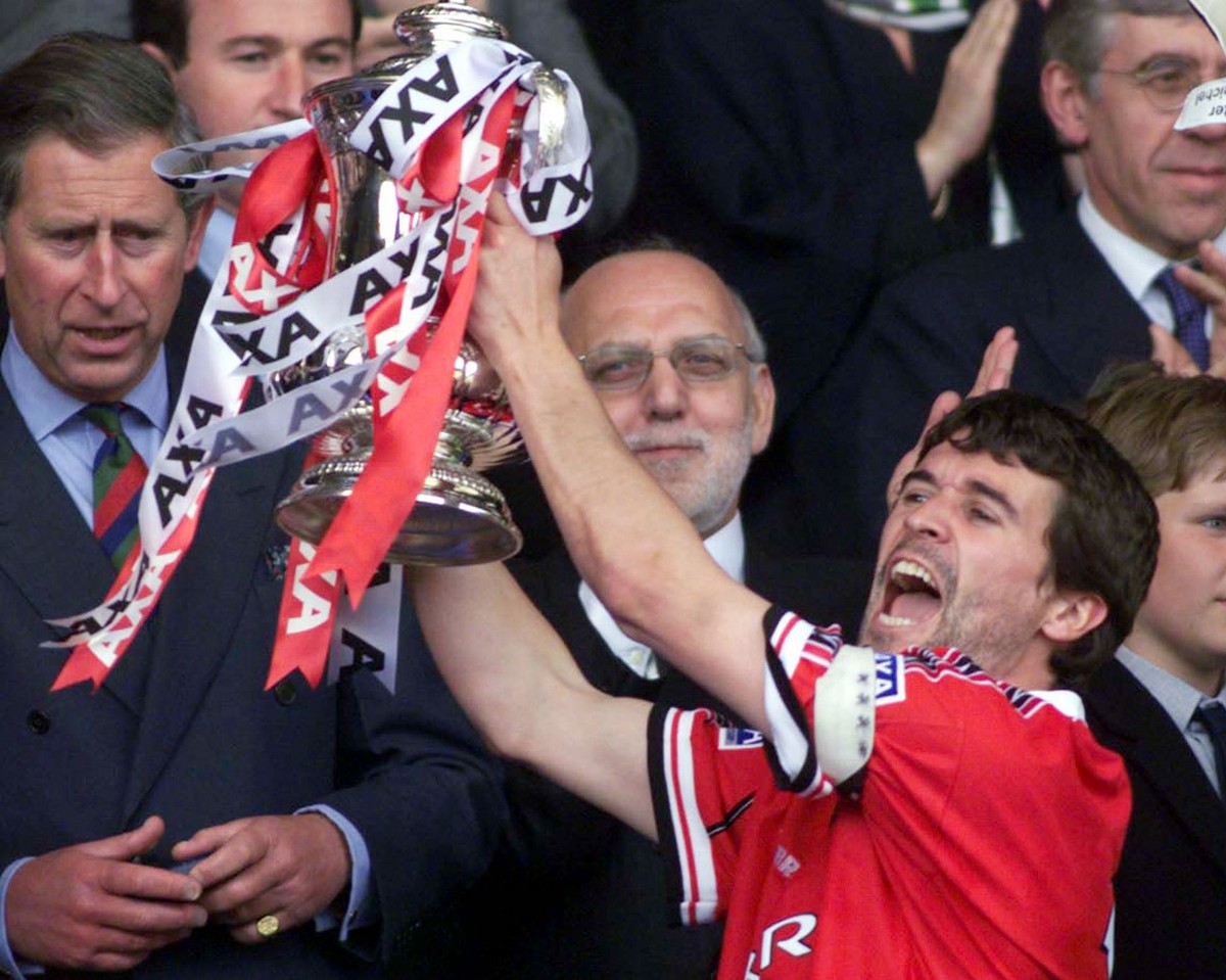 Manchester United' s captain Roy Keane holds up the English Football Association Cup, after defeating Newcastle United 2-0 in the final at London's Wembley stadium, Saturday May 22, 1999. At ...