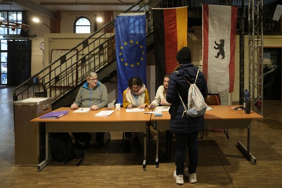 A resident arrives to cast a vote at a polling station in Berlin, Germany, Sunday, Feb. 23, 2025, during the German national election. (AP Photo/Markus Schreiber)