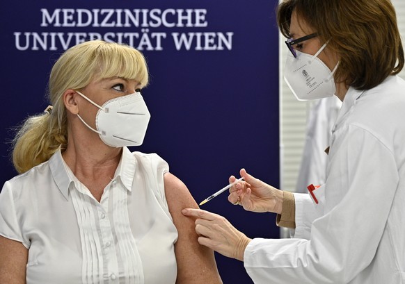 epa08905505 A woman receives one of the first doses of the coronavirus disease (COVID-19) vaccine at the Medical University in Vienna, Austria, 27 December 2020. Austria has received 10.000 doses of t ...