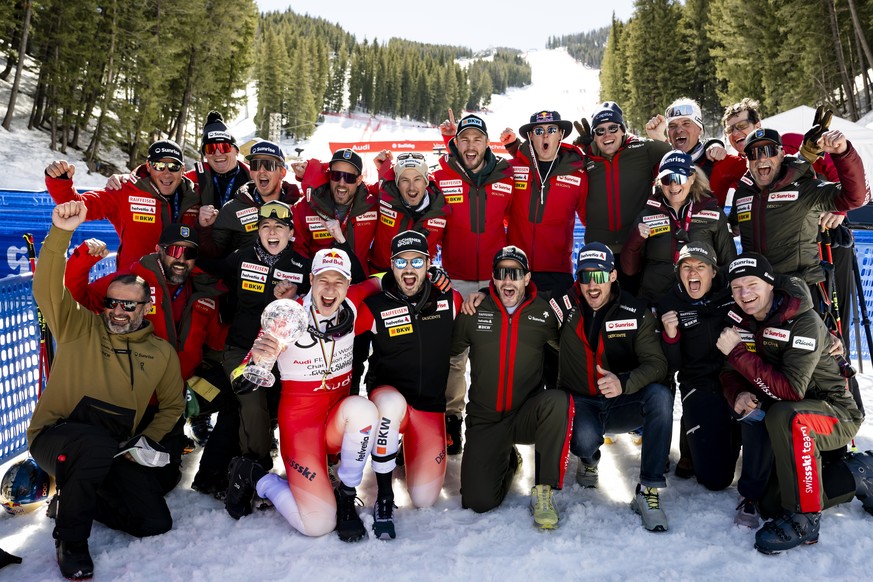 Marco Odermatt of Switzerland, winner of the men&#039;s Giant-Slalom discipline leader crystal globe trophy celebrates with Loic Meillard, winner of the race and Swiss team members during the podium c ...