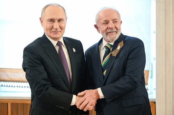 epa12084965 A handout photo made available by Photo host Agency RIA Novosti shows President of Russia Vladimir Putin (L) welcoming President of Brazil Ignacio Lula da Silva before a gala concert held  ...