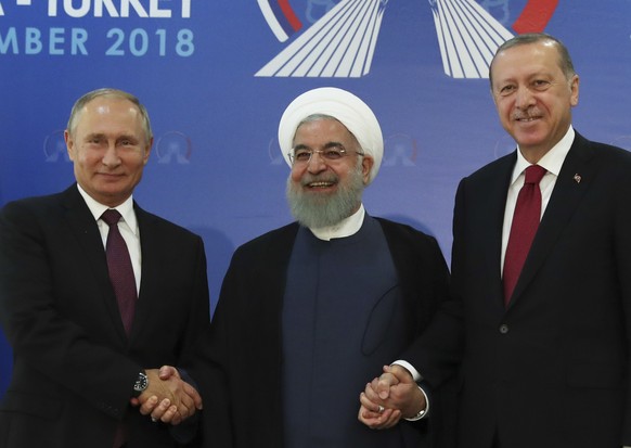 Iran&#039;s President Hassan Rouhani, centre, flanked by Russia&#039;s President Vladimir Putin, left, and Turkey&#039;s President Recep Tayyip Erdogan, pose for photographs in Tehran, Iran, ahead of  ...