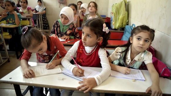 In this Tuesday Sept. 11, 2018 photo, schoolchildren attend a class in the northern town of Jisr al-Shughur, Syria, west of the city of Idlib. Syrian government forces, backed by Russia and Iran, have ...