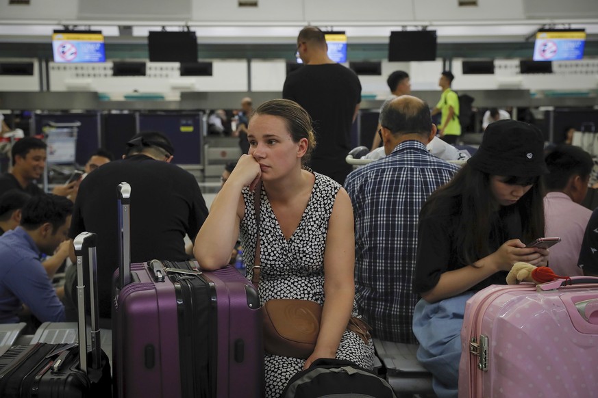 Australian Penny Tilley, center, reacts next to stranded travelers at the closed check-in counters at the Hong Kong International Airport, Monday, Aug. 12, 2019. One of the world&#039;s busiest airpor ...