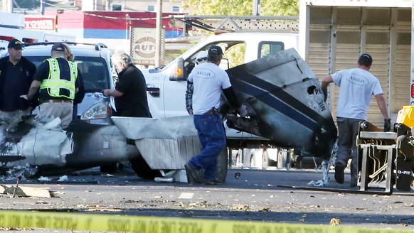 Wreckage is removed from the scene of a twin-engine plane that struck a utility pole and burst into flames in downtown East Hartford, Connecticut U.S., October 12, 2016. REUTERS/Michelle McLoughlin TP ...