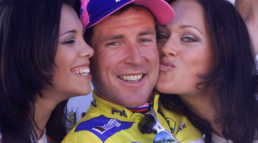 CAPTION CORRECTION - DATE: Swiss racer Oscar Camenzind, center, enjoys the kisses of the former Miss Switzerland, Sonia Grandjean, left, and Tania Gutmann, wearing the yellow jersey as the overall lea ...