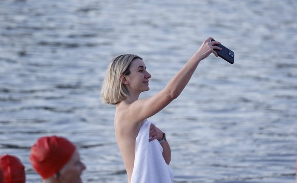 epa10026904 A swimmer takes a selfie after the annual nude winter solstice swim, during Hobart&#039;s Dark Mofo festival at Long Beach, in Sandy Bay, Tasmania, Australia, 22 June 2022. EPA/ROB BLAKERS ...