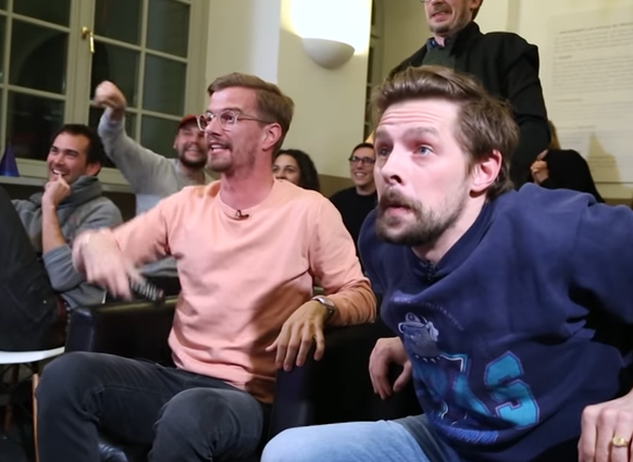 Joko und Klaas fiebern vor dem Fernseher mit.