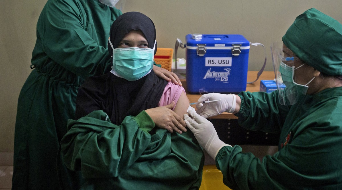 Dr. Lili Rahmawaty gives a shot of COVID-19 vaccine to a colleague at the North Sumatra University Hospital in Medan, North Sumatra, Indonesia, Wednesday, Jan. 20, 2021. The world's fourth most p ...