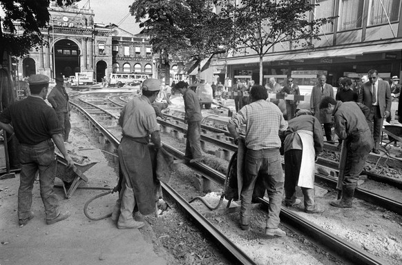 Bauarbeiter spitzen waehrend den Bauarbeiten an der Bahnhofunterfuehrung und der Ladenpassage Shopville unter dem Bahnhofplatz in Zuerich, Schweiz, den Asphalt zwischen den Tramgleisen am Anfang der B ...