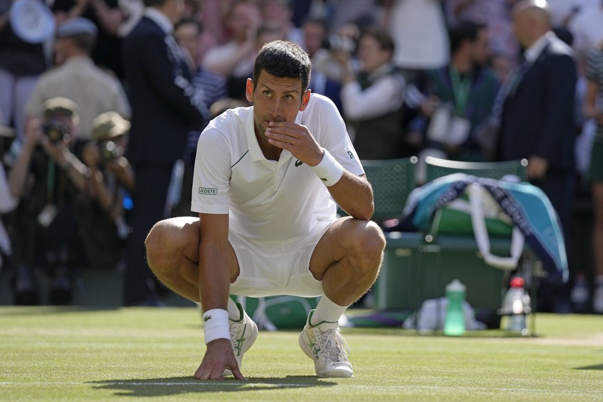 Serbia&#039;s Novak Djokovic eats some grass that he plucked from the surface of the court as he celebrates after beating Australia&#039;s Nick Kyrgios to win the final of the men&#039;s singles on da ...