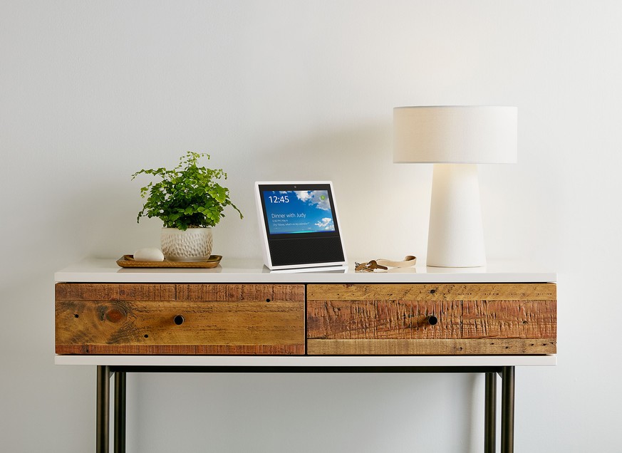 This photo provided by Amazon shows an Amazon Echo Show on display in a living room setting. Amazon is giving its voice-enabled Echo speaker a touch screen and video-calling capabilities as it compete ...