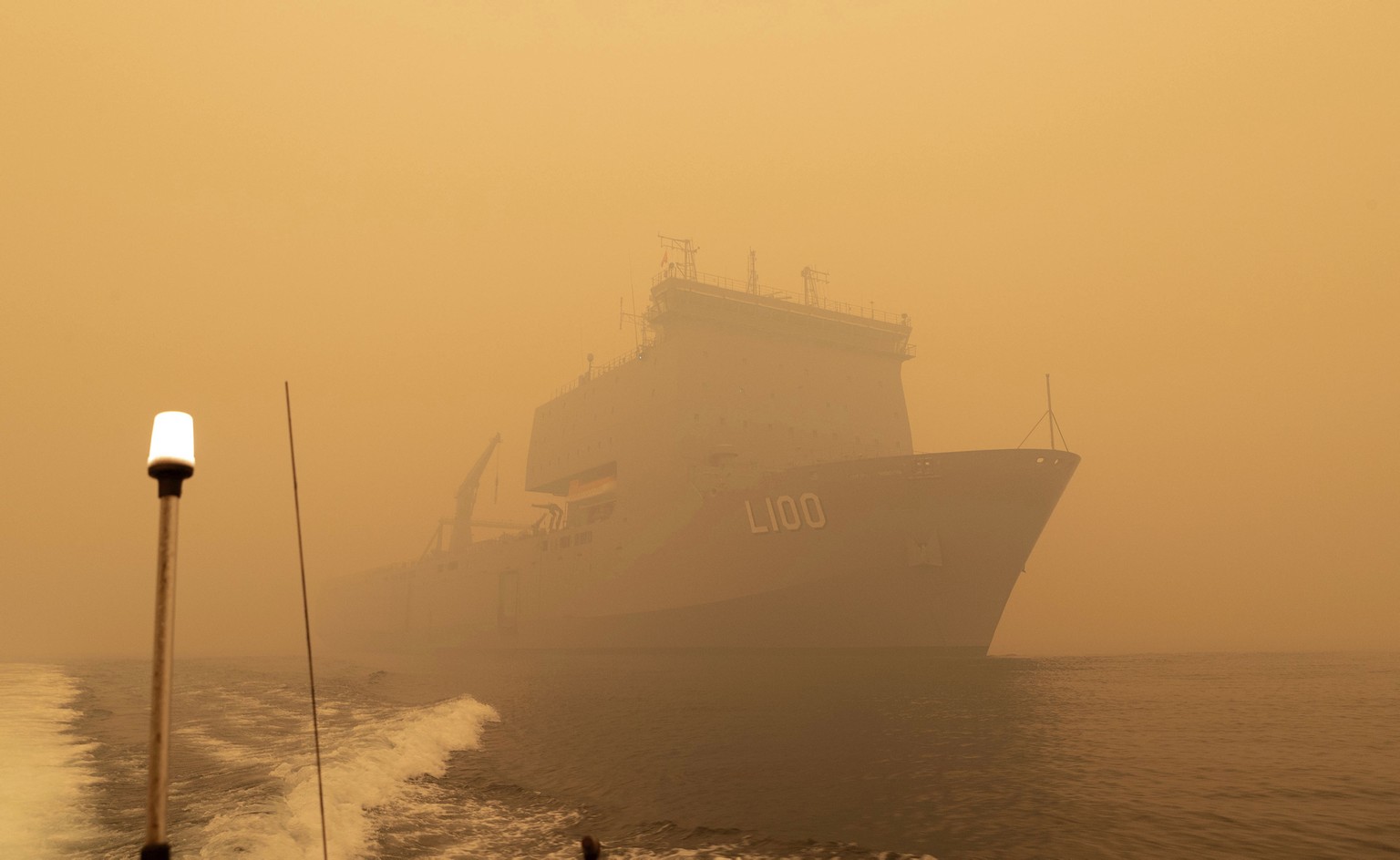 In this photo released and taken Jan. 2, 2020, by the Australian Department of Defense, the HMAS Choules sails off the coast of Mallacoota, Victoria to supply support to people cut off by bush fires. ...