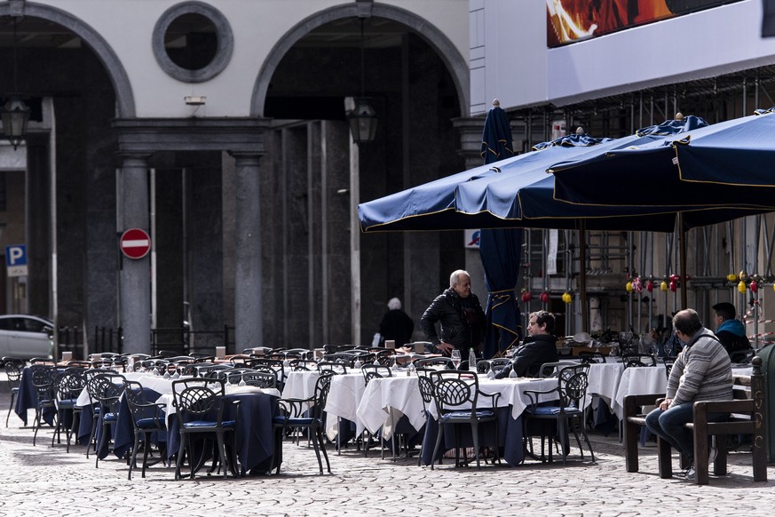 Few people sit at tables outside a bar in the center of Turin, Northern Italy, Sunday, March 8, 2020. Italy announced a sweeping quarantine early Sunday for its northern regions, igniting travel chaos ...