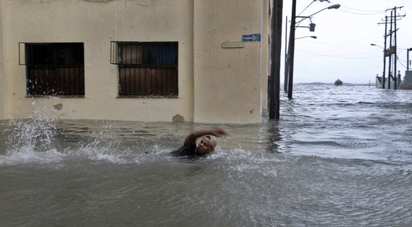 epa06196607 A man swims on a flooded street in Havana, Cuba, 10 September 2017. Severe storm surge flooding cut power and forced the evacuation of thousands of people in the aftermath of Hurricane Irm ...