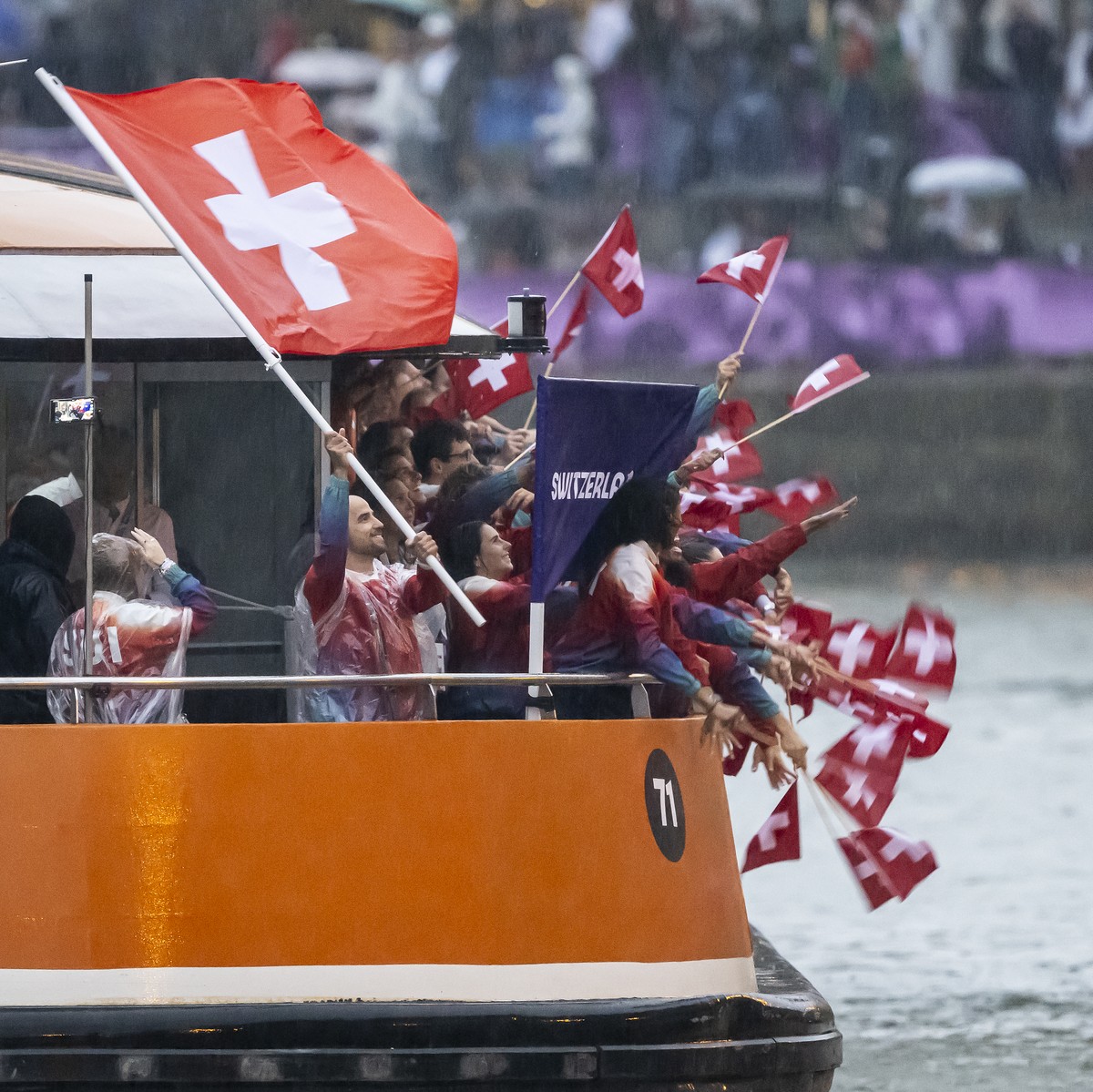 Switzerland's flag-bearer mountainbiker Nino Schurter celebrates with Swiss athletes on a boat, during the opening ceremony of the 2024 Paris Summer Olympics on the Seine river in Paris, France,  ...