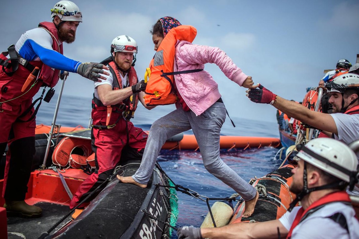 epa06683364 Members of the NGO 'SOS Mediterranee' from the 'Aquarius' vessel help a woman during an operation to rescue more than 250 migrants on a wooden boat, about 50 kilometers ...