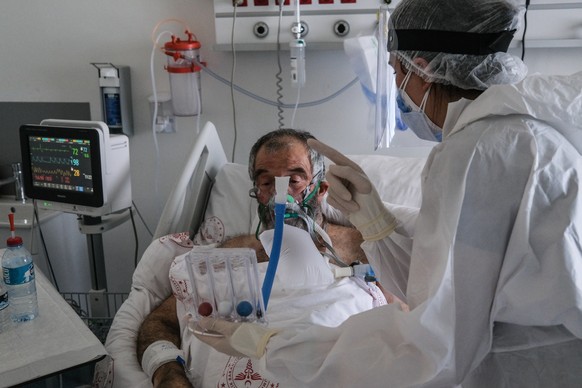 epa09170295 A medical worker wearing Personal Protective Equipment (PPE) attends to Aslan Unver (66), a COVID-19 patient at the Intensive Care Unit (ICU) of the Dr. Feriha Oz Emergency Hospital, in Istanbul, Turkey, 30 April 2021. Turkish President Recep Tayyip Erdogan announced a total lockdown between 30 April to 17 May due to increased Covid-19 cases. The lockdown coincides with the festival of Eid al-Fitr, which marks the end of the Muslim fasting month of Ramadan. The toll from coronavirus-related deaths has risen in Turkey to 39,737 people in total as of 30 April 2021, with the country reporting 4,788,700 confirmed cases.  EPA/SEDAT SUNA