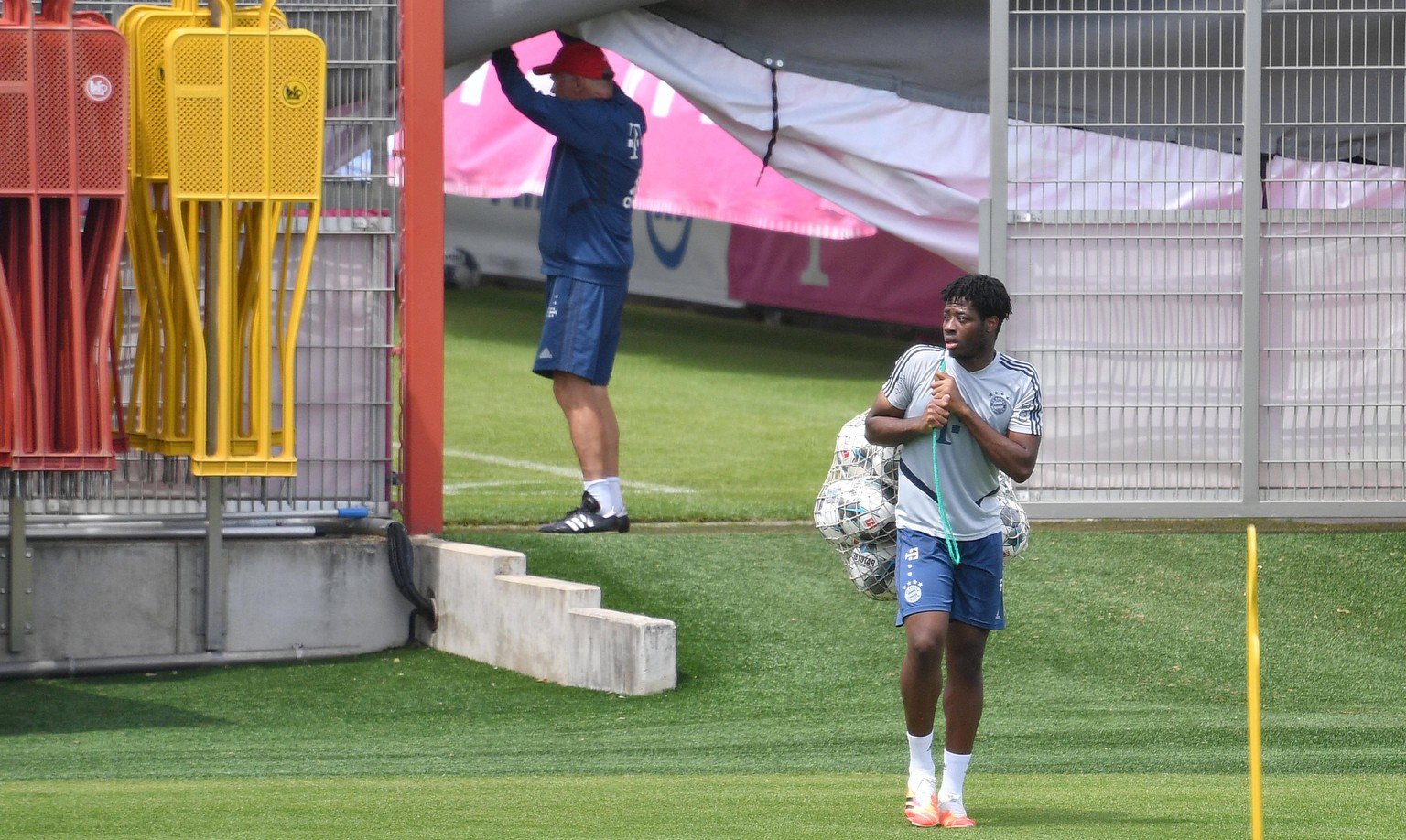 Bright Akwo Arrey-Mbi traegt ein Netz mit Baellen. FC Bayern Muenchen Training in der Coronavirus Pandemie. Training an der Saebener Strasse. Fussball 1. Bundesliga,Saison 2019/2020, am 03.06.2020 *** ...