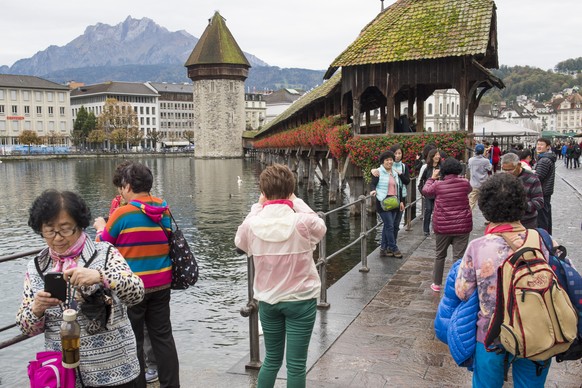 Touristen aus Asien fotografieren am Donnerstag, 16. Oktober 2014, in Luzern die Kapellbruecke und den Wasserturm. (KEYSTONE/Sigi Tischler)