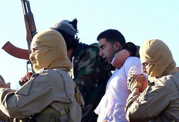 IS-Mitglieder mit dem Gefangenen.&nbsp;