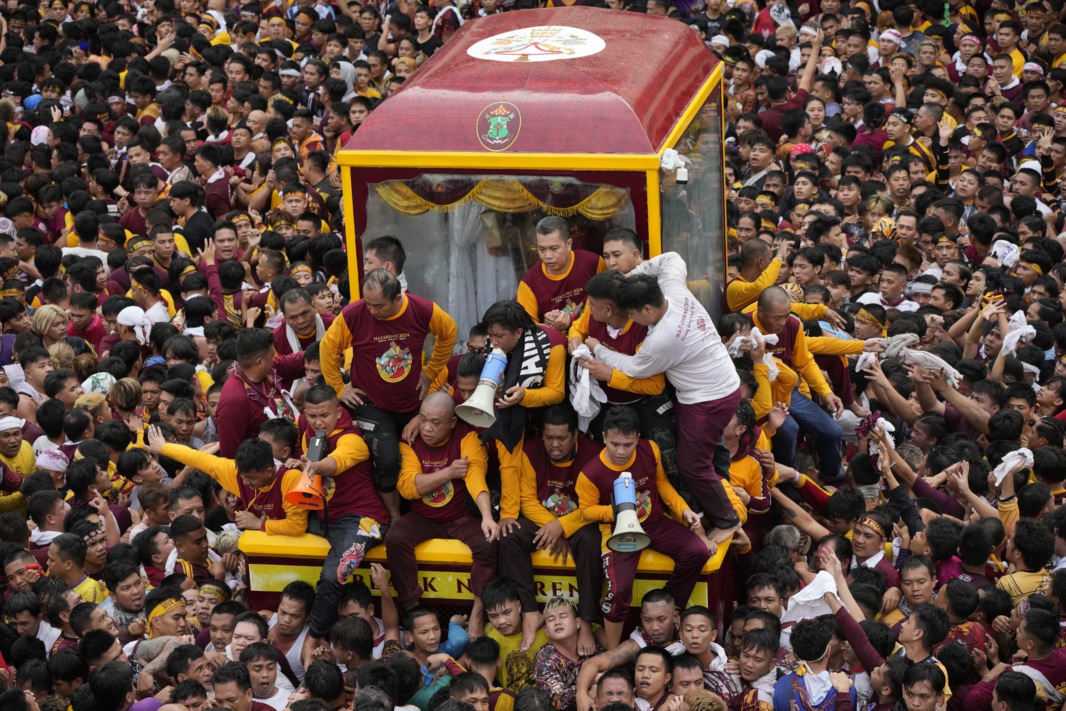 Devotees react as they try to block others from climbing on the glass-covered cart carrying Black Nazarene during its annual procession which was resumed after a three-year suspension due to the coron ...