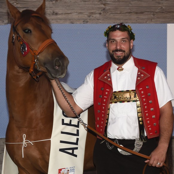 Innerschweizer Schwinger Daniel Boesch erhaelt den von Feldschloesschen gesponserten Lebendpreis, die Freiberger Stute Allegra. Ehemaliger Eishockeyspieler Mathias Seger (links) und Zuechter ueberreic ...