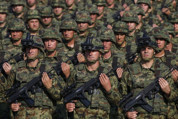 FILE - Serbian Army soldiers perform during a military parade at the military airport Batajnica, near Belgrade, Serbia, on Oct. 19, 2019. Serbia looks set to reintroduce the obligatory military servic ...