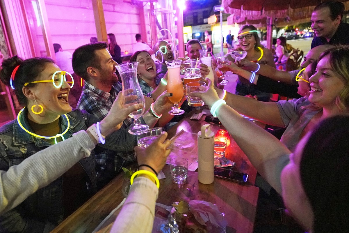 Emily Baumgartner, left, and Luke Finley, second from left, join friends from their church group in a birthday toast to one of the members, upper right, during their weekly "Monday Night Hang&quo ...