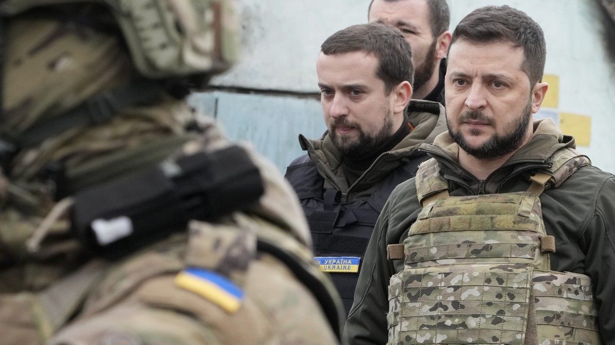Ukrainian President Volodymyr Zelenskyy examines the site of a recent battle in Bucha, close to Kyiv, Ukraine, Monday, Apr. 4, 2022. Russia is facing a fresh wave of condemnation after evidence emerge ...