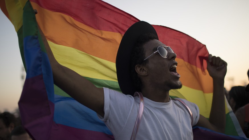 A music fan waves a gay movement flag as he listens to a performance at the Rock in Rio music festival in Rio de Janeiro, Brazil, Sunday, Sept. 17, 2017. (AP Photo/Leo Correa)